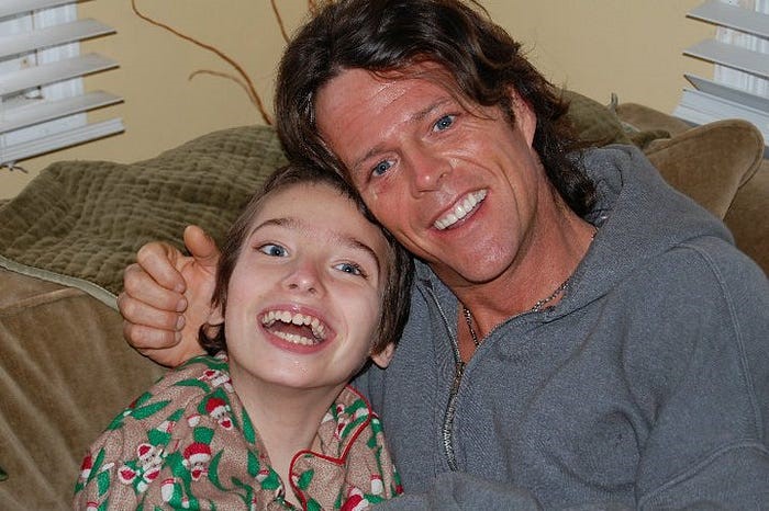 Father smiling and posing with a disabled son